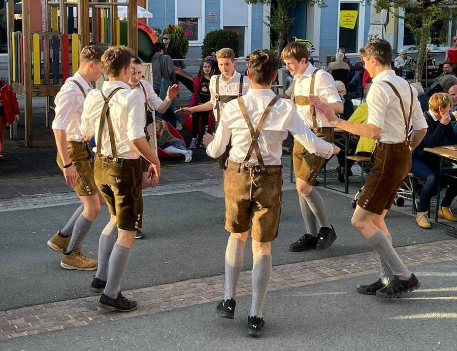 Plattler tanzen auf einem Platz vor Zuschauern